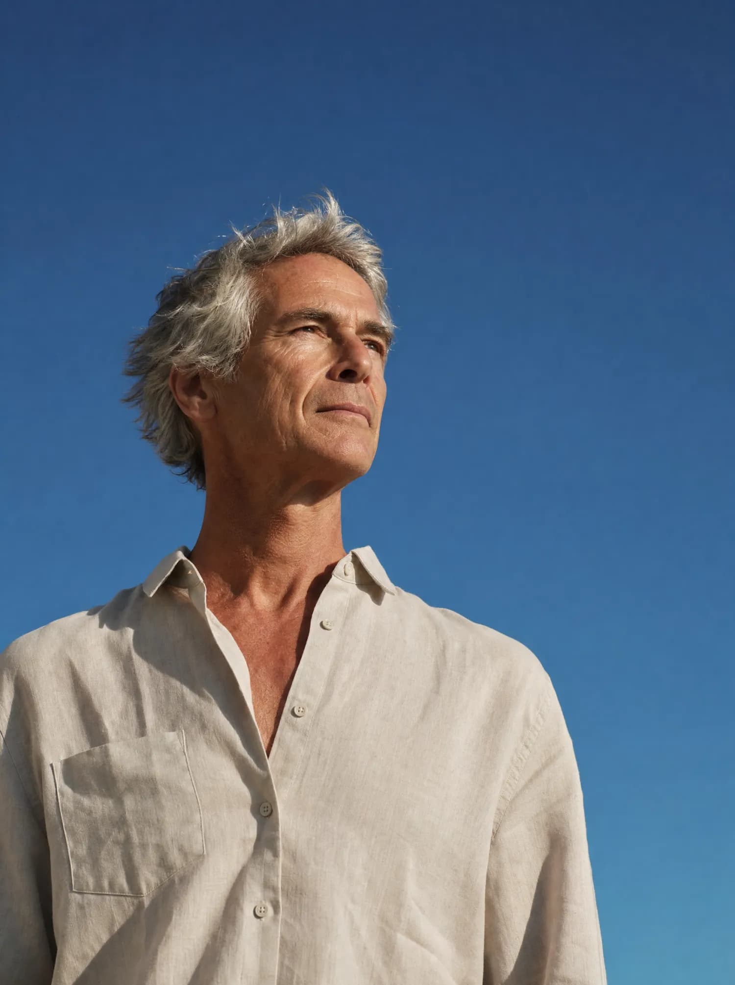 A man against a deep blue sky, looking toward the food